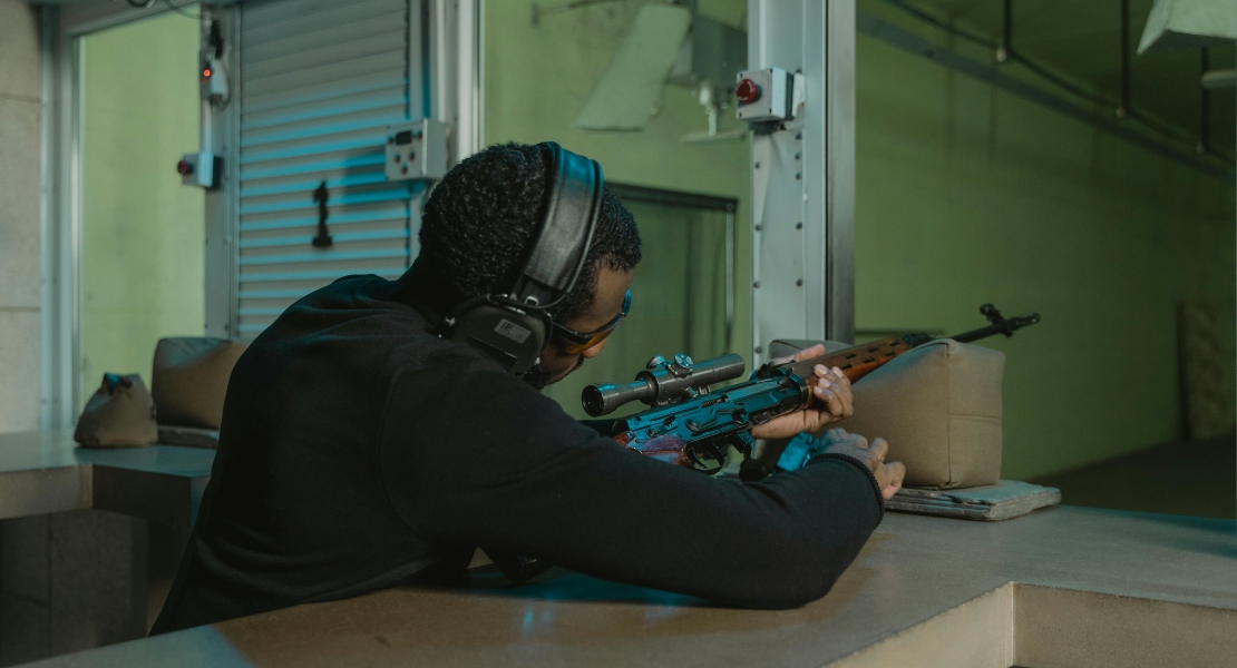 a man shooting with a rifle gun
