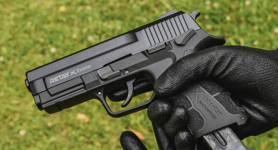 A person holding a gun, explaining how firearm triggers work.