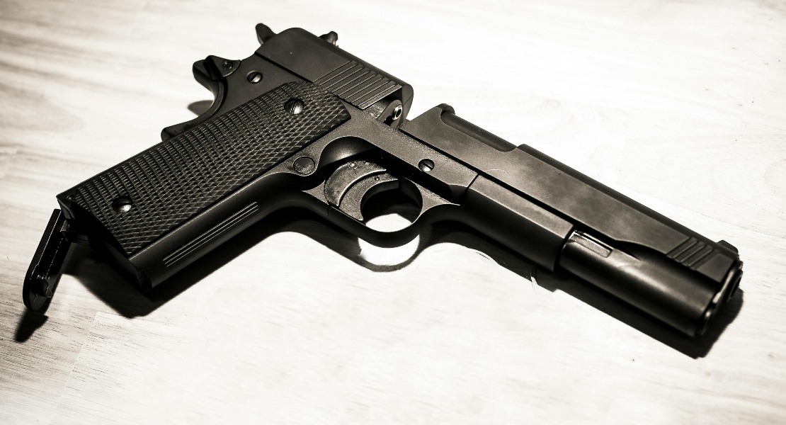 A close-up of a gun on the table.