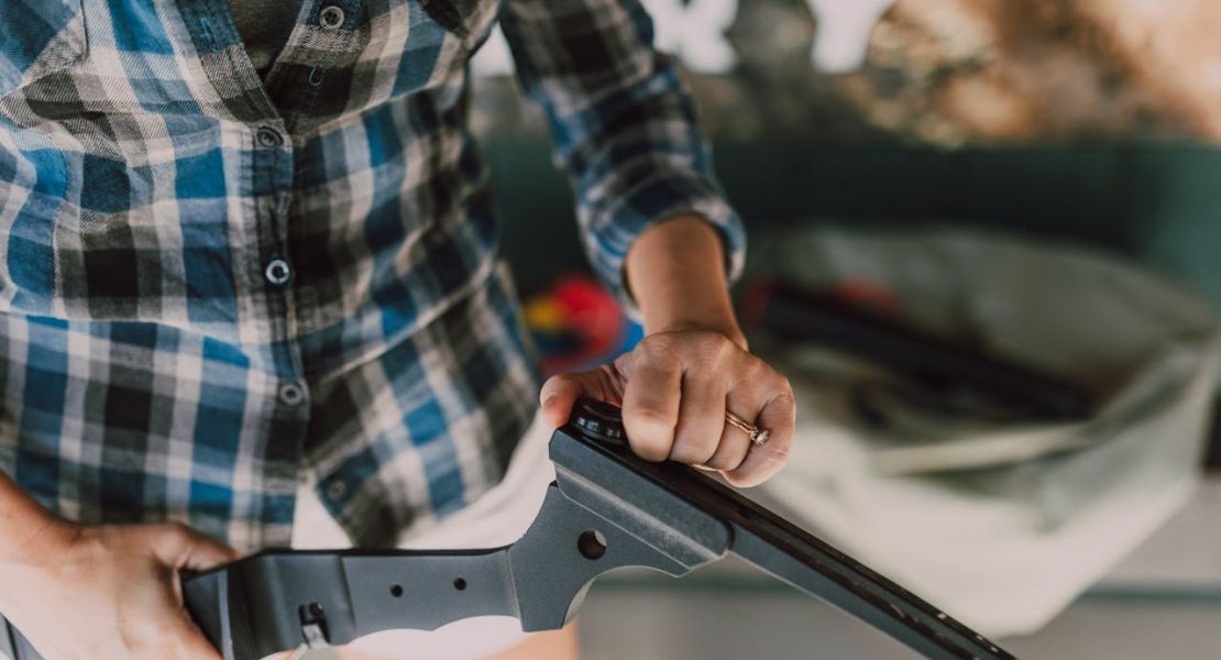 a woman working on AK-47 lubrication and maintenance