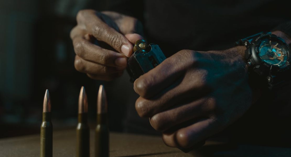 a man holding a bullet and a gun