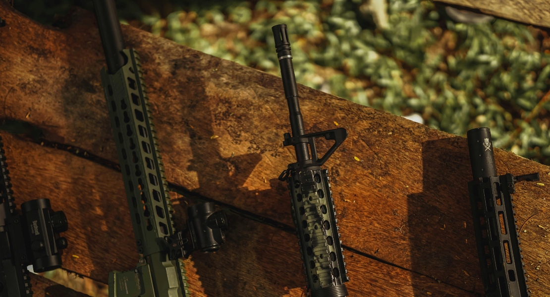 A gun resting on a wooden fence.