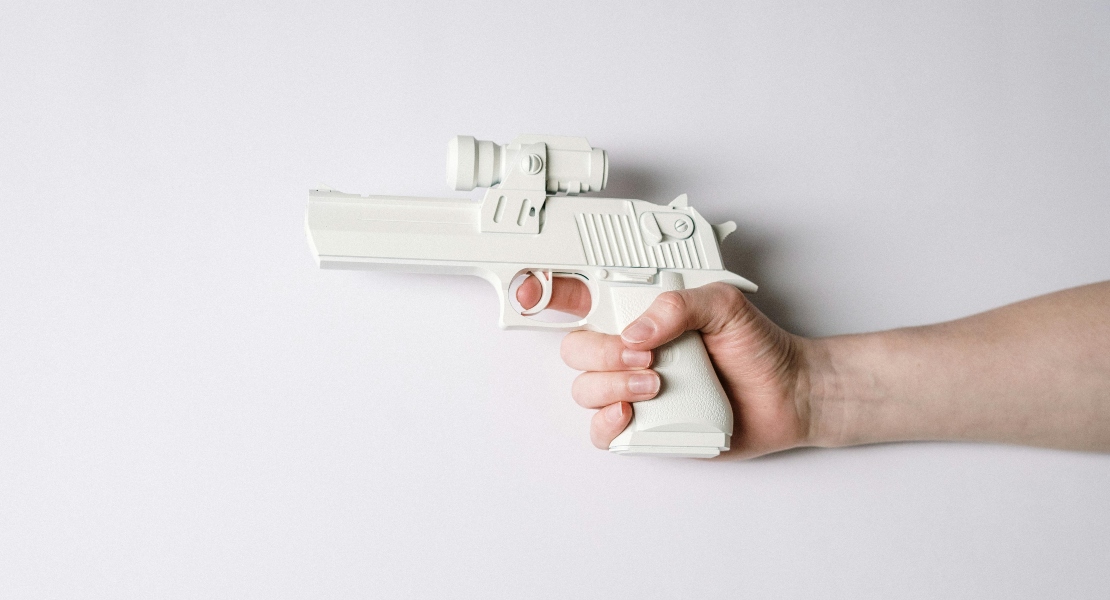 Person holding white semi-automatic pistol with Cerakote finish highlighting smooth, durable firearm coating.