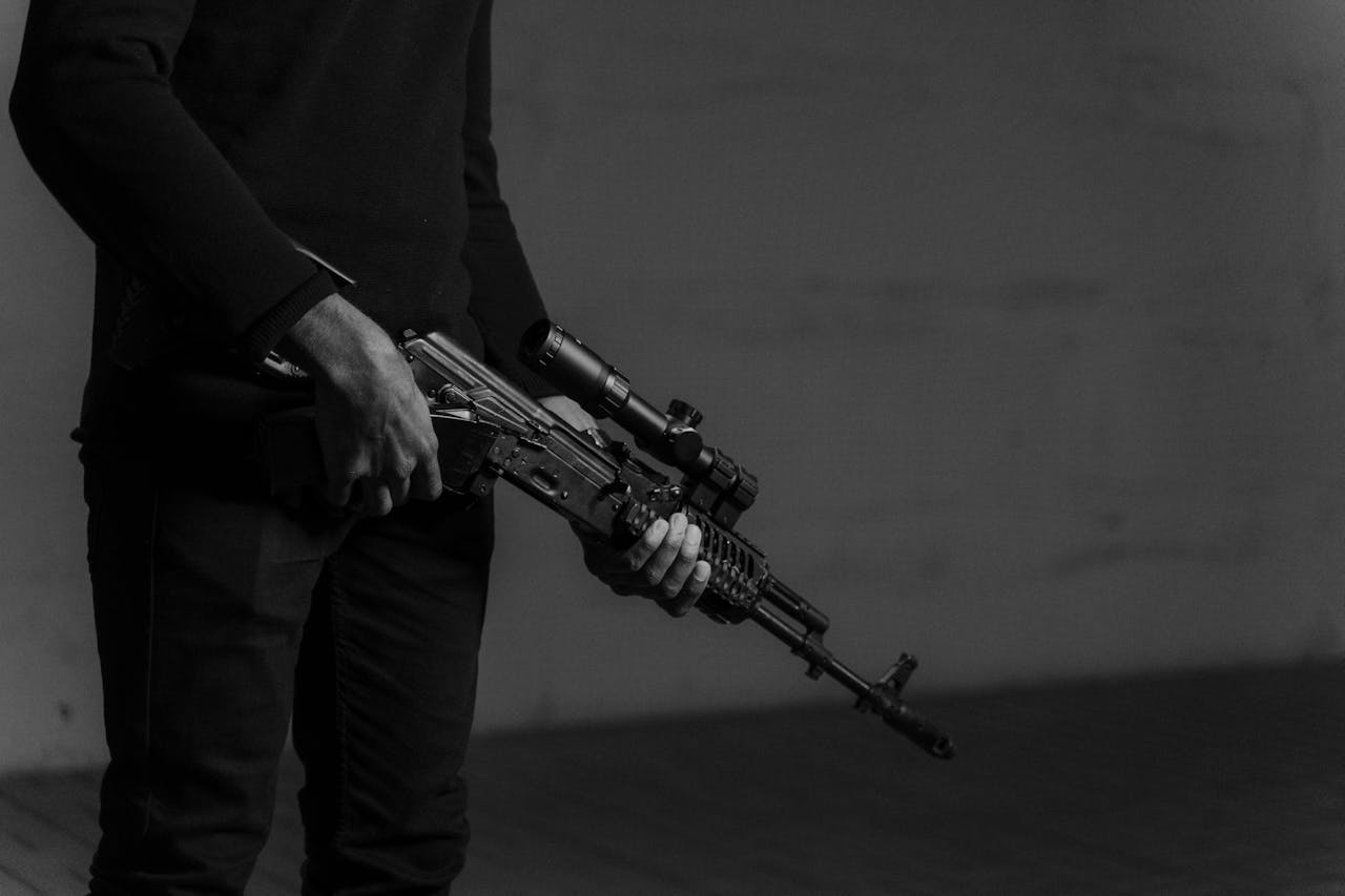 a person holding ak rifle