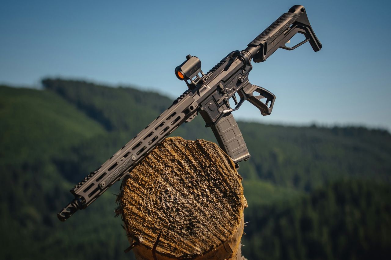 black assault rifle on brown wooden log
