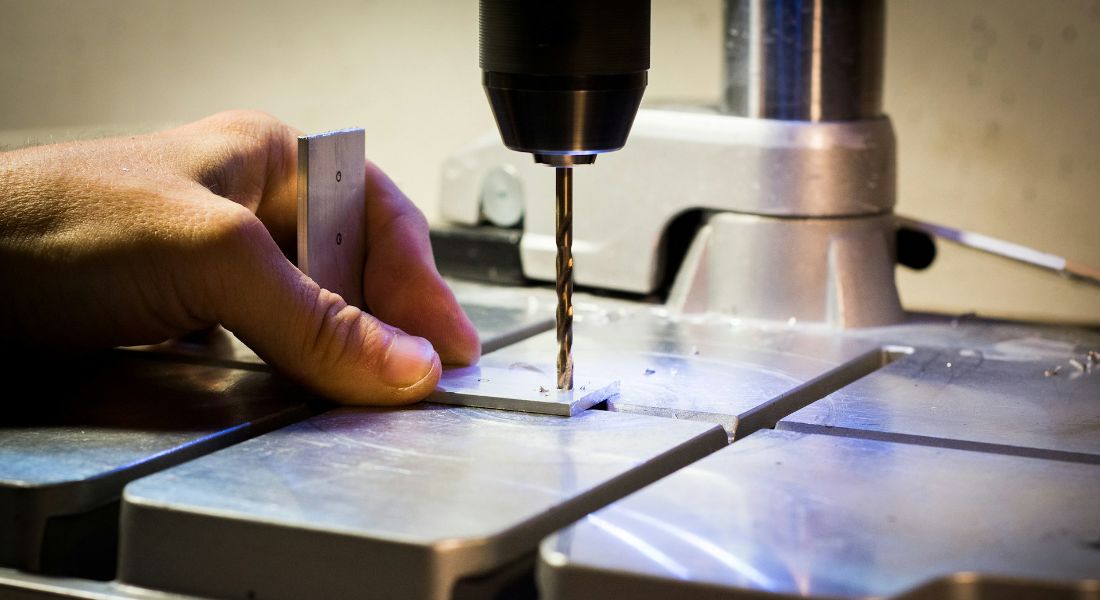 a person working on some aluminum parts