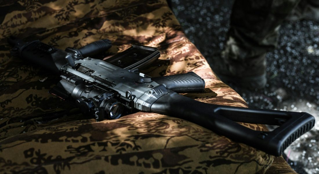 a black rifle placed on a couch