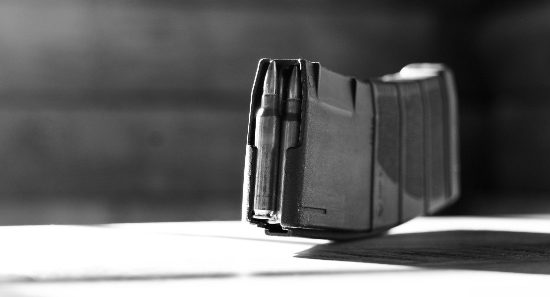 A full gun magazine standing on a desk.