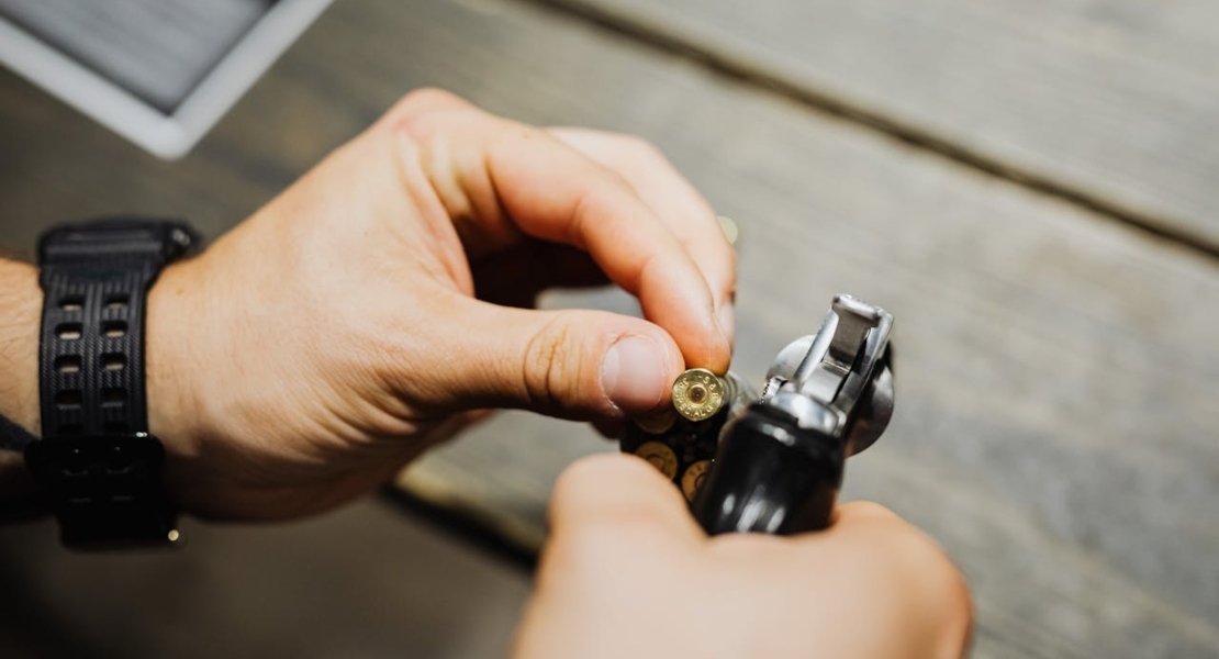 a man holding a gun and checking the bullet