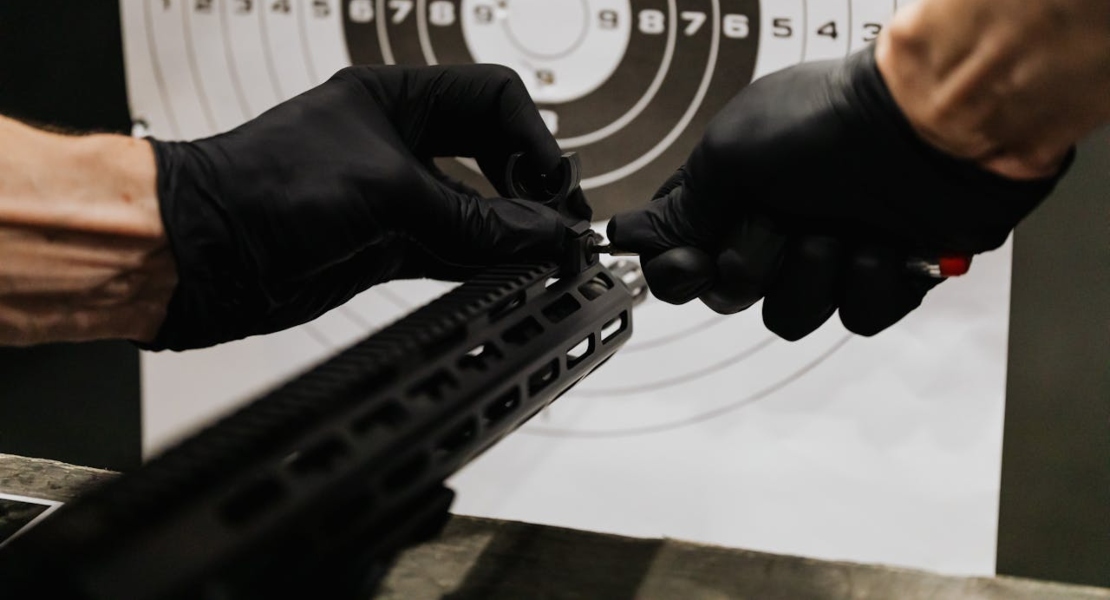 a man holding a gun and comparing 316 stainless steel vs 6061 aluminum firearm parts