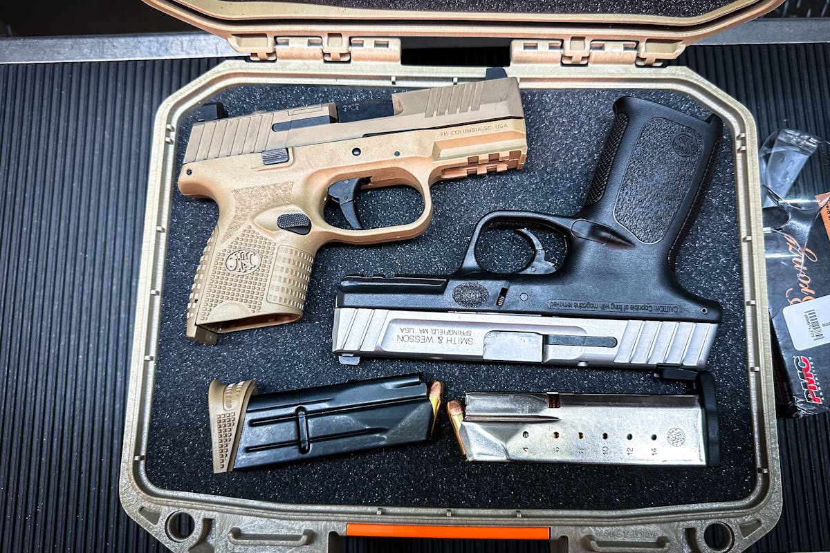 two guns storred in a case with magazines next to them