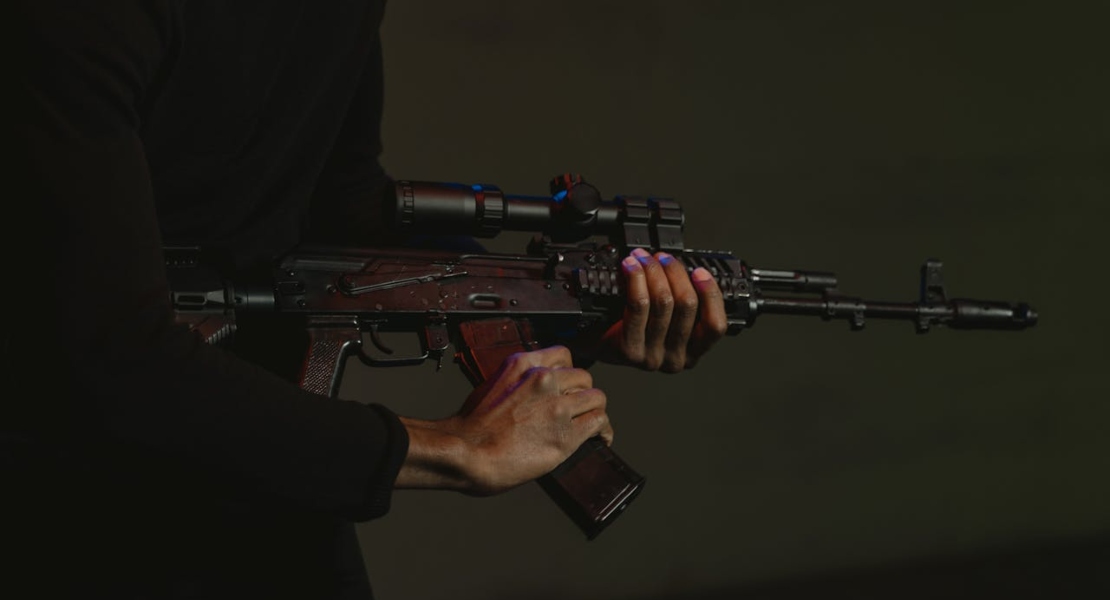 person holding a rifle while checking component fit and alignment