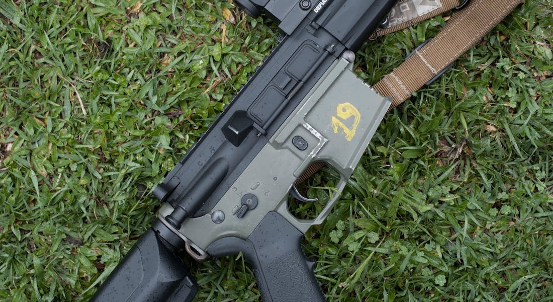 Rifle lying on green grass outdoors