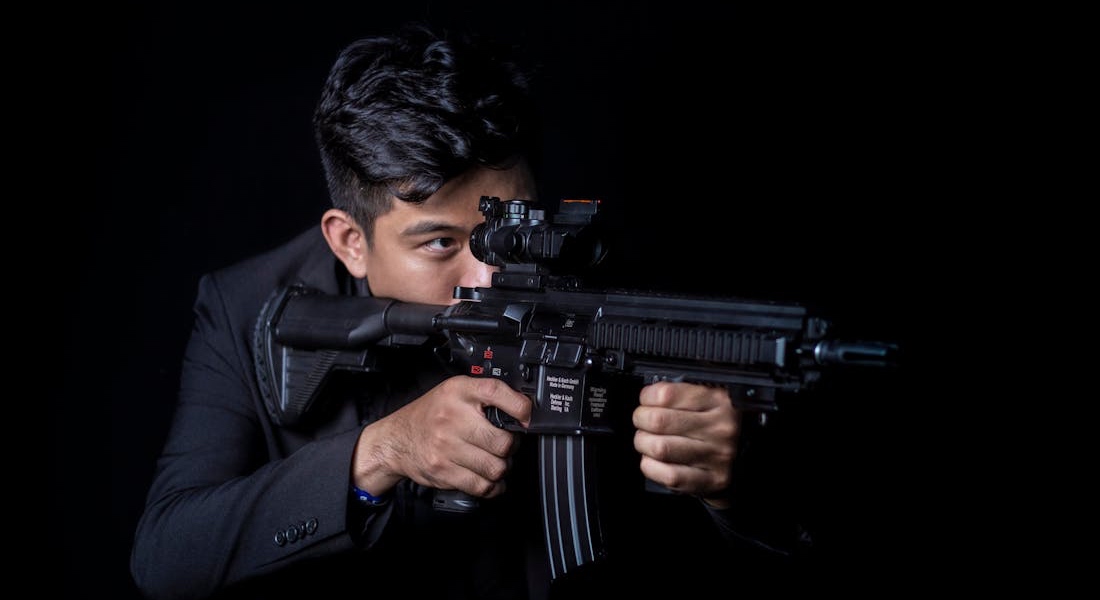 A person aiming an MP5 rifle
