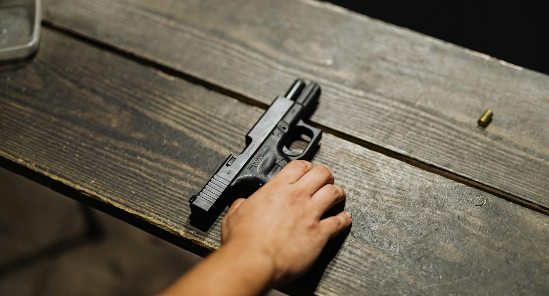 A person holding the gun, showing the difference between lightweight vs heavy duty firearm parts.