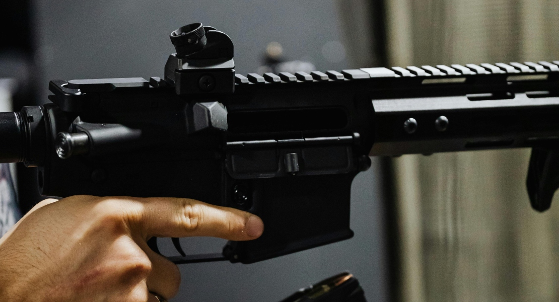 A hand holding an AR-15 and inspecting AR-15 super safety maintenance