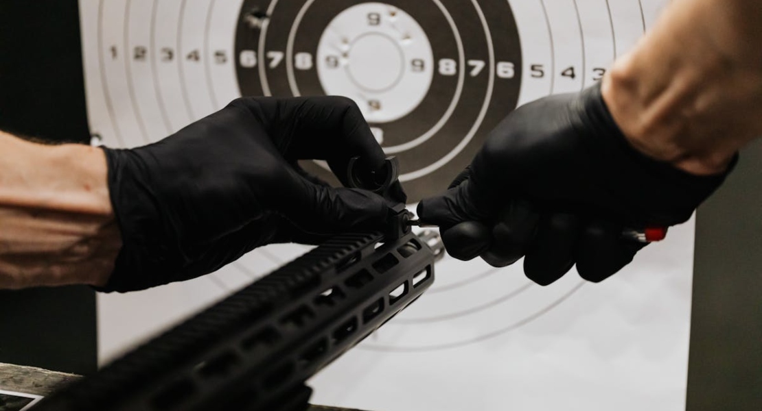 Hands adjusting the firearm parts.