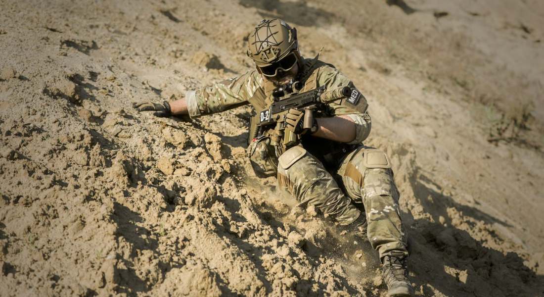 a soldier on a hill with a gun