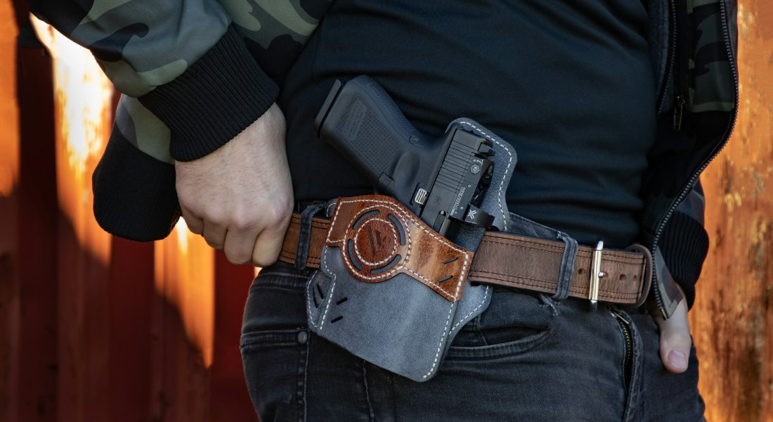 a man who learned how to transport firearms safely, carrying a gun in a holster around his weist