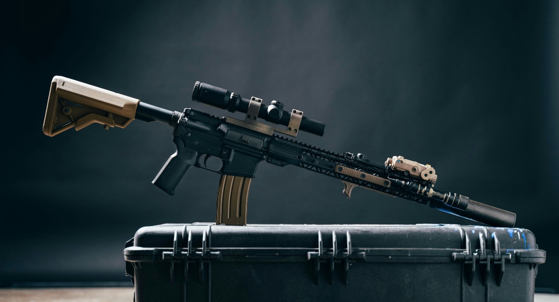 An AR-15 super safety suppressor standing on a rifle case.
