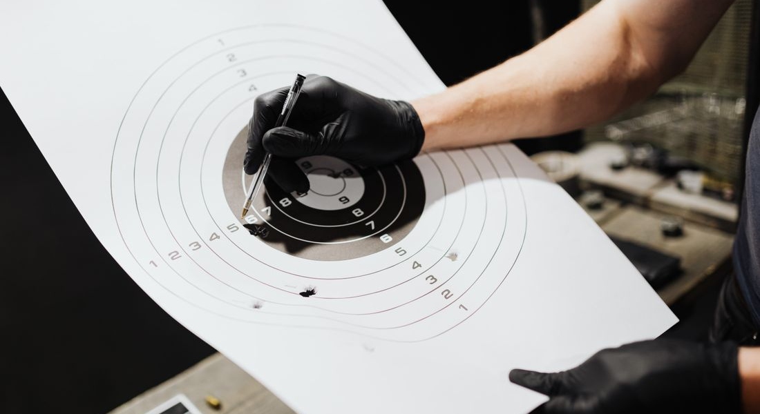 Person marking hits on a shooting target after AK super safety maintenance