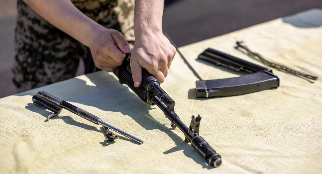 A man disassembling a rifle.