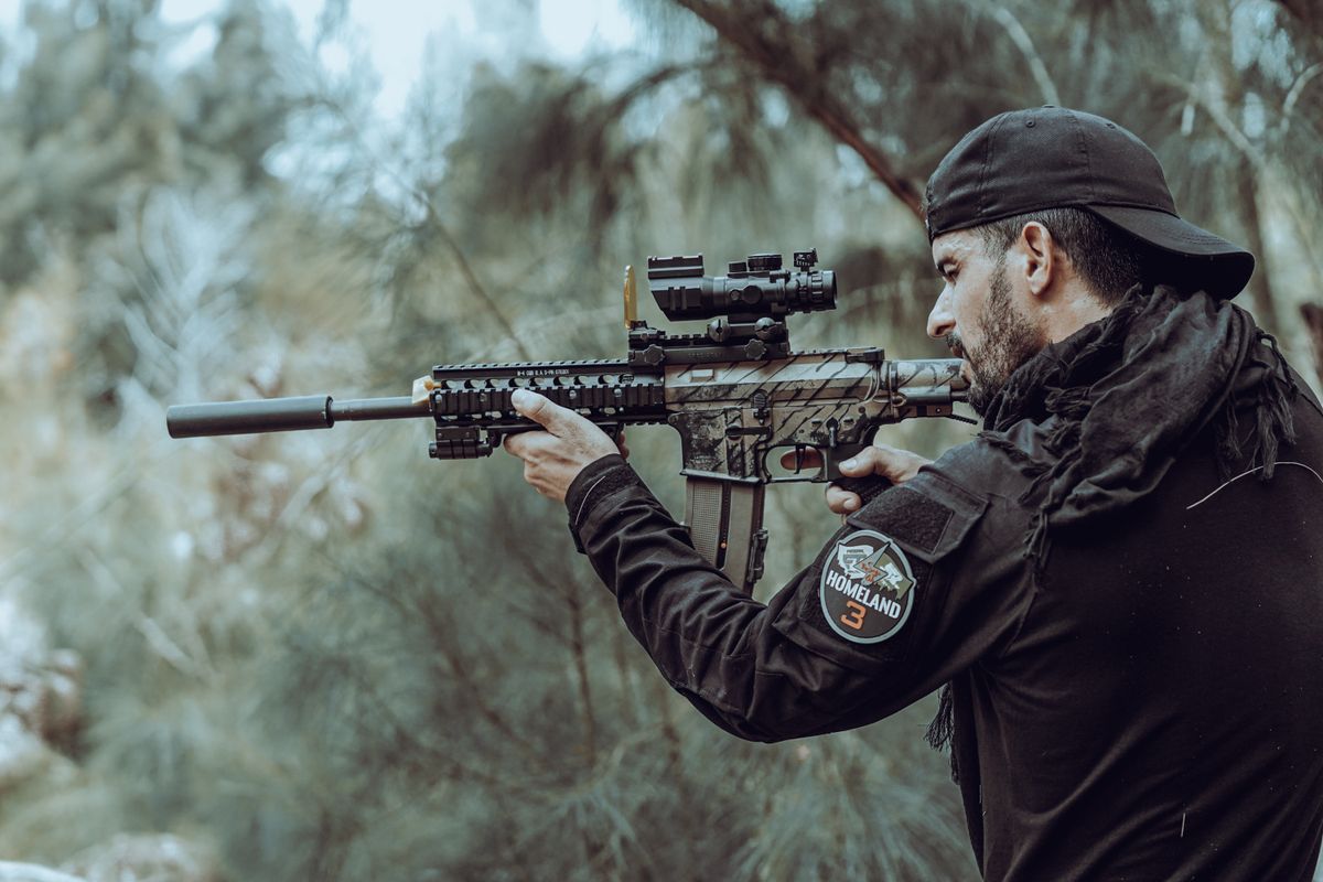 a man aiming with an a15 surrounded by trees
