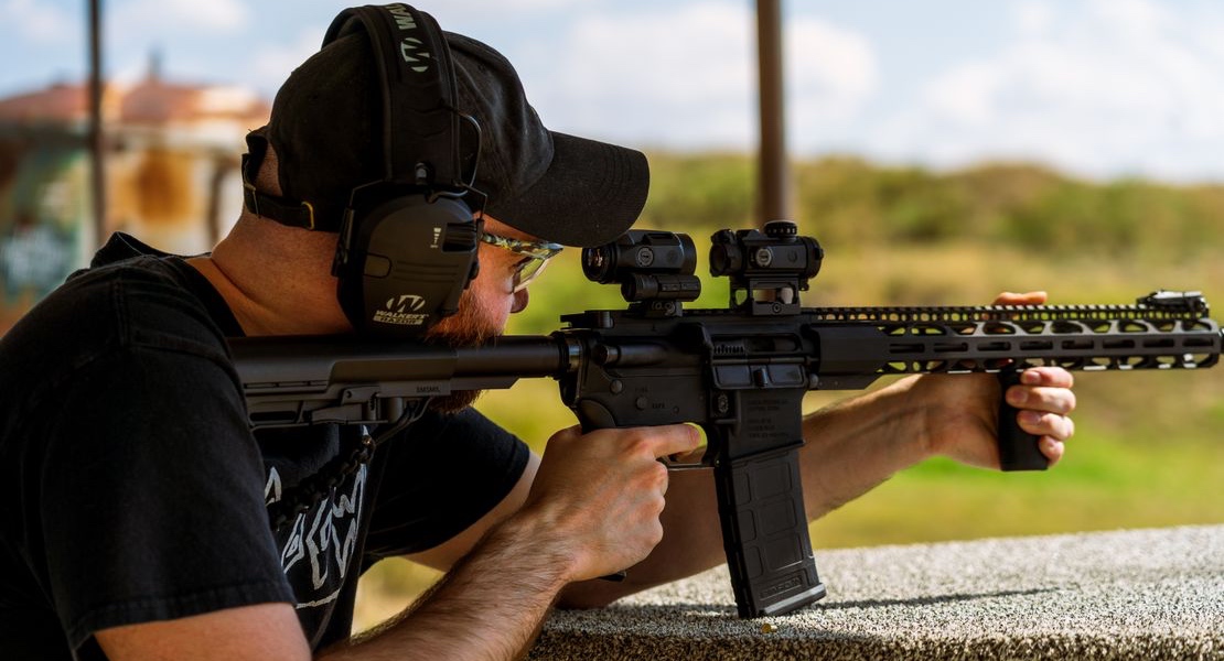 Person testing super safety trigger group compatibility with an AR-15 at an outdoor range