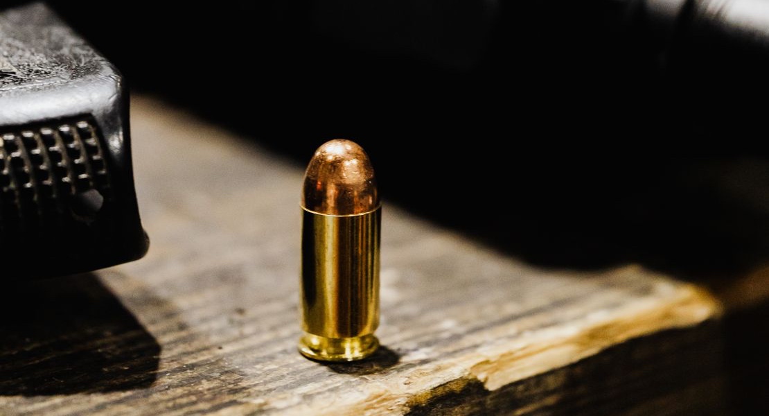 Single cartridge standing on a wooden surface