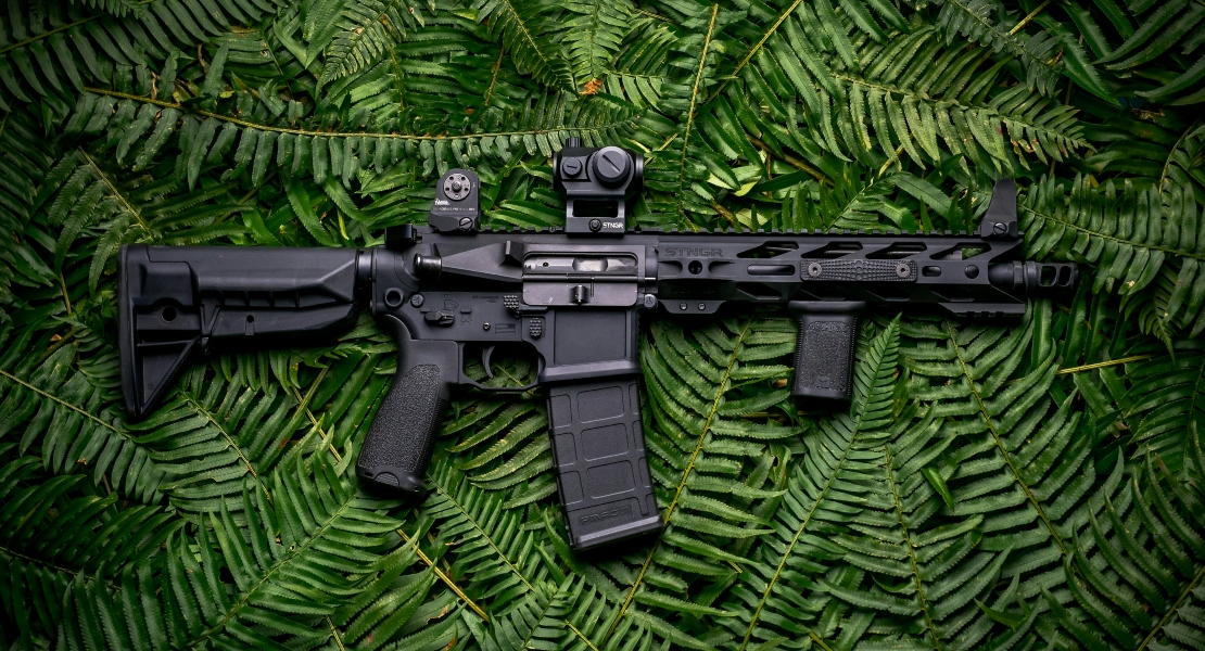 An AR15 rifle on the grass.