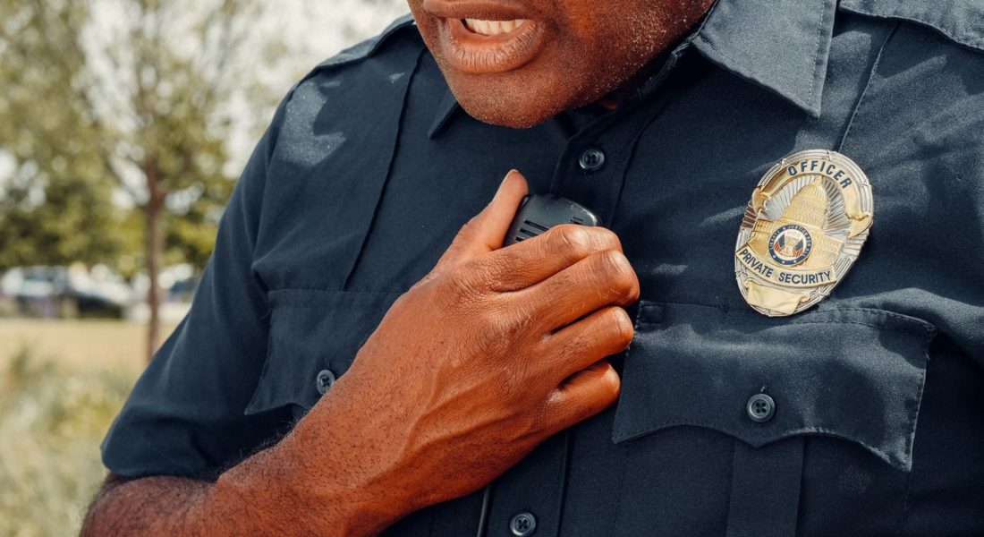 a close-up of a security officer using a radio outdoors