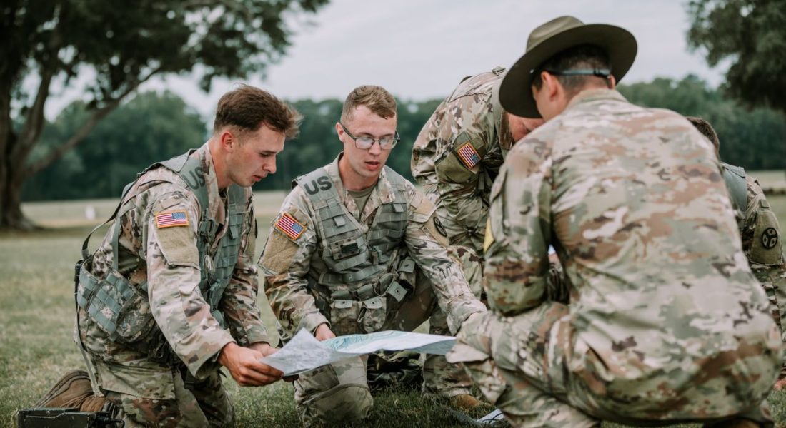 U.S. soldiers in camo gear analyze a map