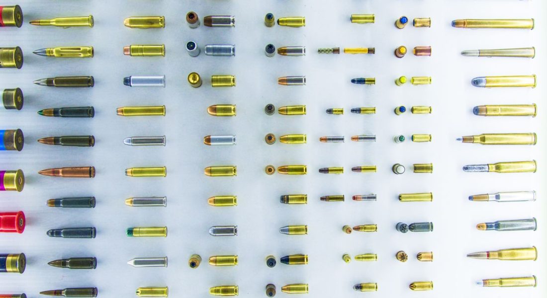 a high-angle view of various bullet casings neatly arranged on a white surface