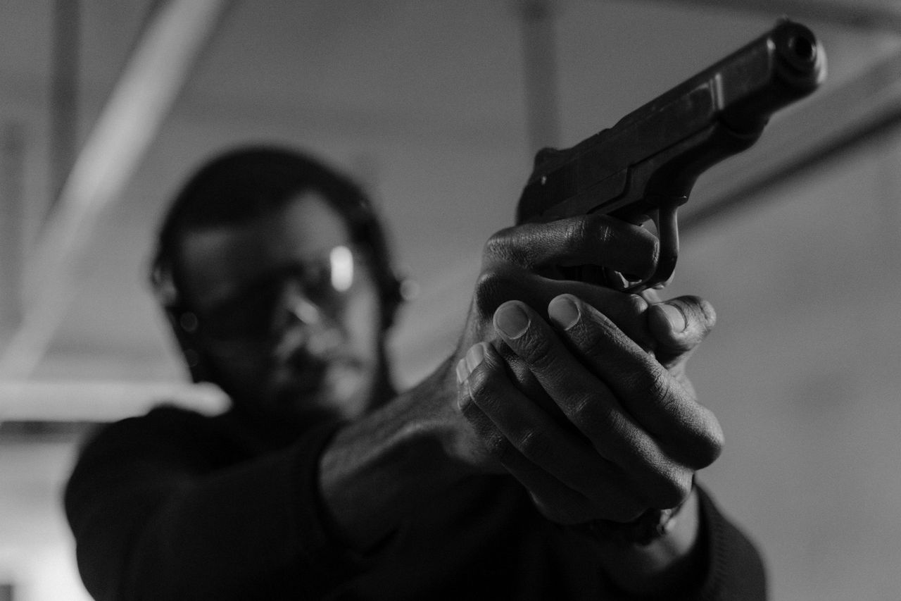 a man aiming a handgun indoors