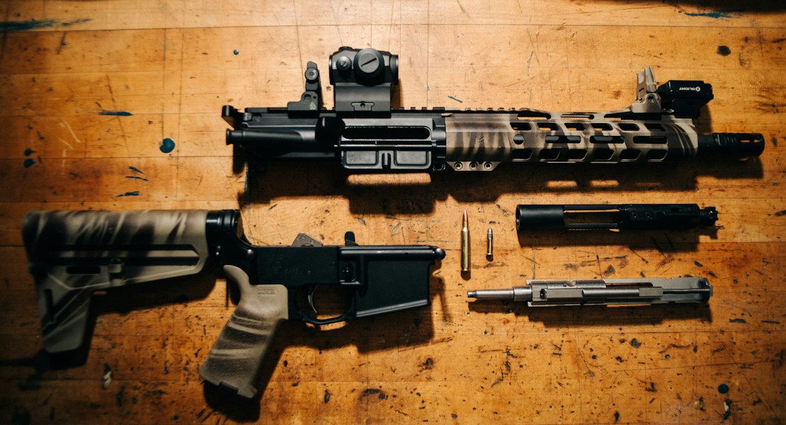 Disassembled AR-15 showing the bolt carrier group that drives an FRT trigger reset