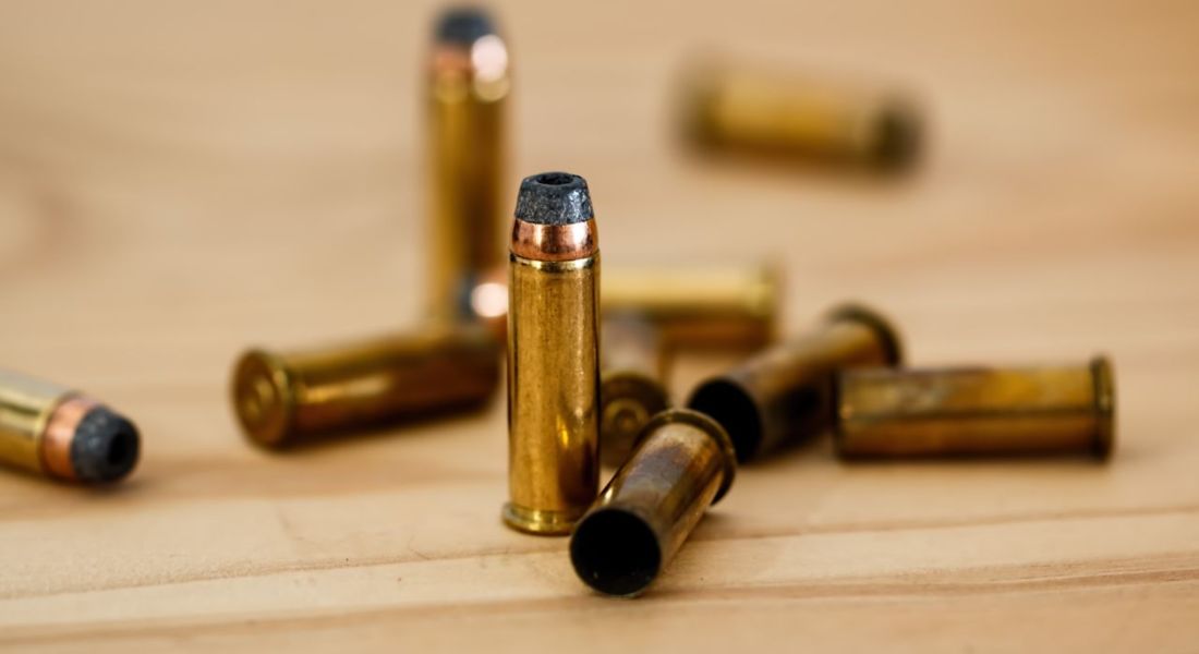Detailed view of brass bullet shells scattered on a wood background