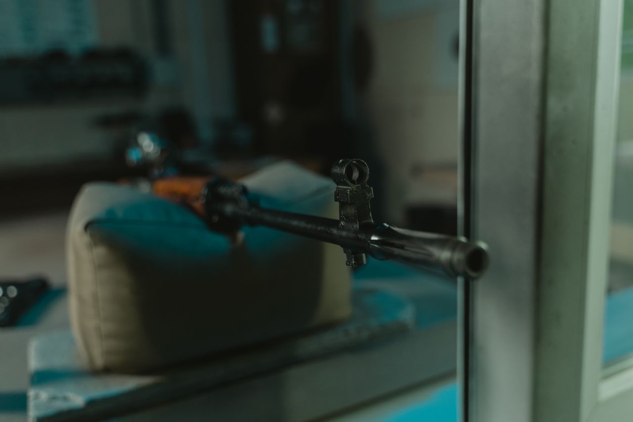 a detailed view of a rifle barrel indoors, focused on muzzle